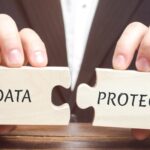 Businessman collects wooden puzzles with the word Data Protection