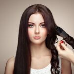Hairdresser woman curls her hair