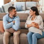 Happy couple choosing the sofa and bed in the store