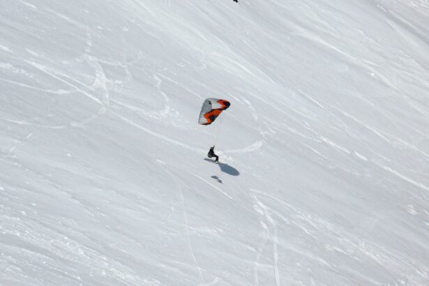 Person snowkiting down a snowy slope.