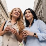 Two middle-aged caucasian women sisters best friends girlfriends looking for new clothes