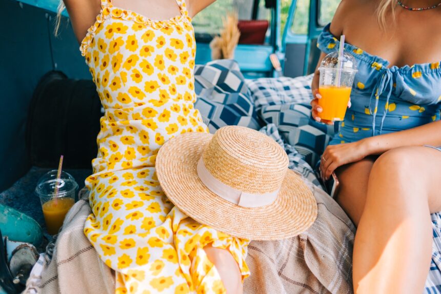 Two women sitting in a van in stylish summer outfit.