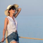 Young woman in casual outfit relaxing on seaside on warm summer day