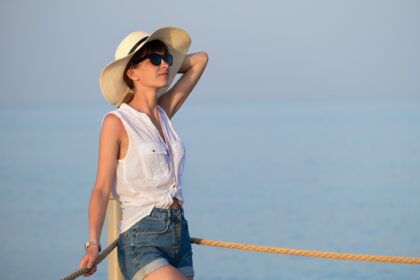 Young woman in casual outfit relaxing on seaside on warm summer day