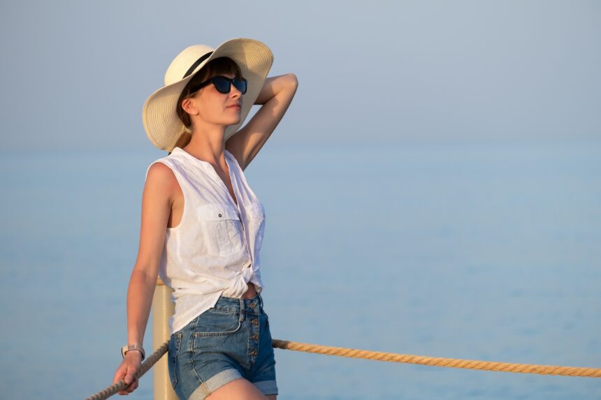 Young woman in casual outfit relaxing on seaside on warm summer day